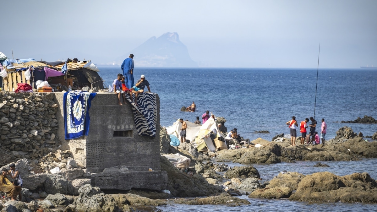 Varios migrantes asentados en la playa del Trampolín, a 31 de agosto de 2026, en Ceuta