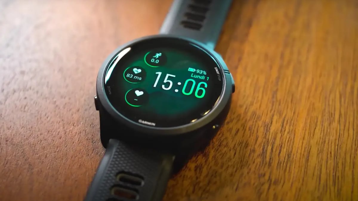Reloj Garmin Forerunner 265 negro sobre una mesa de madera, con la esfera encendida mostrando la hora y el pulso