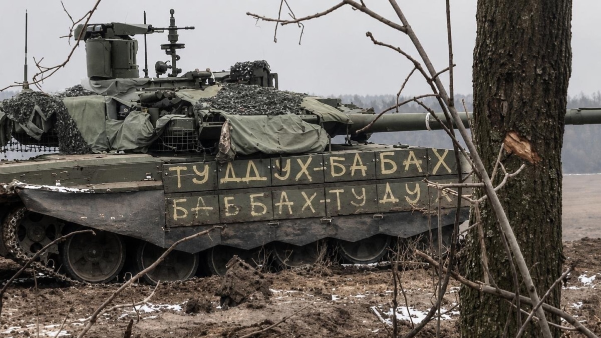 Tanque modelo T-90M "Proryv" ruso en el frente. El lateral imita en cirílico el sonido de cañonazos: "ТУДУХ-БАБАХ / БАБАХ-ТУДУХ" (¡Pum-Kabum!).