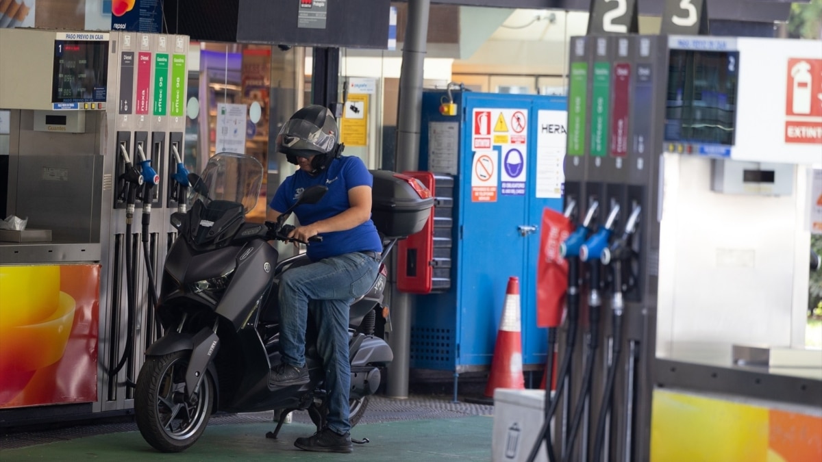 Una persona reposta el combustible de su moto.