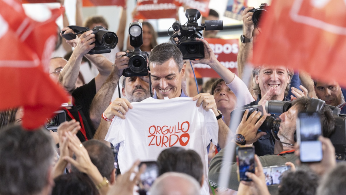 El secretario general del PSOE y presidente del Gobierno, Pedro Sánchez, muestra la camiseta con la leyenda 'Orgullo zurdo' por la visita de Javier Milei a España a su llegada al mitin en Burgos de este 21 de octubre de 2026.