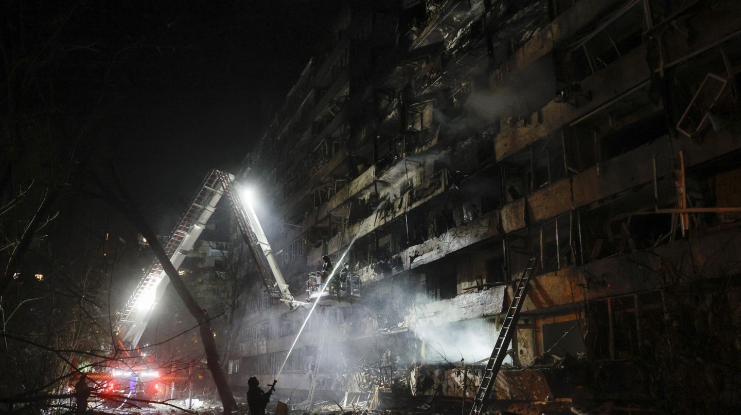 Equipos de emergencia ucranianos prestan asistencia traes el impacto de un misil en un edificio residencial en Kiev.