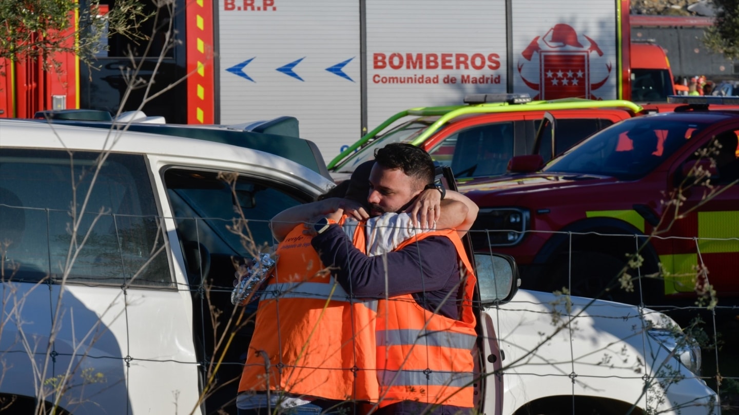 Dos personas se abrazan en la zona cero del accidente de Urda.