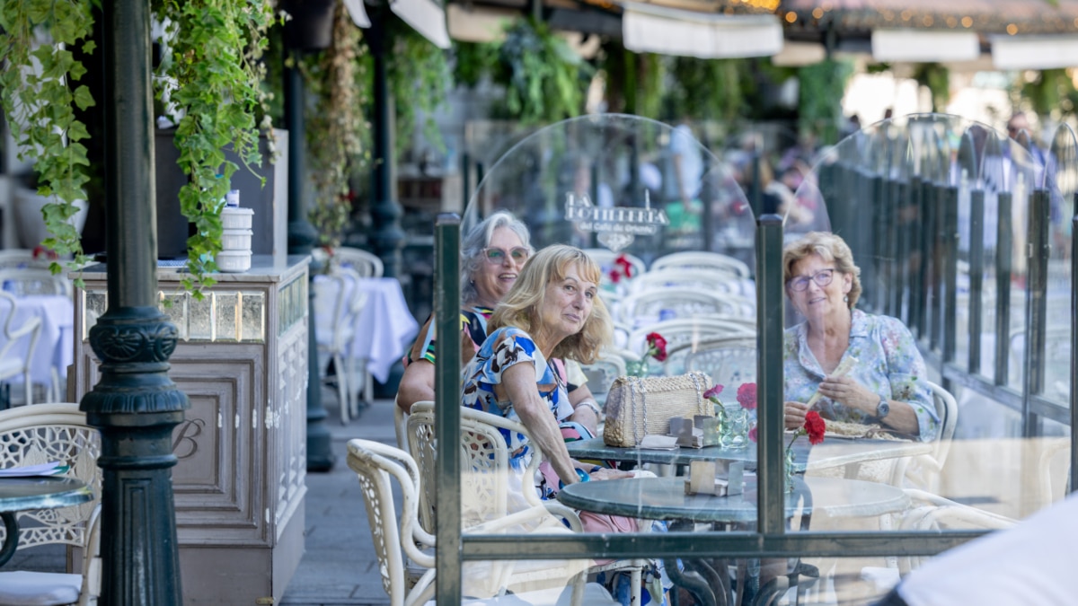 Clientes de un bar se refrescan en la terraza, en Madrid (España).