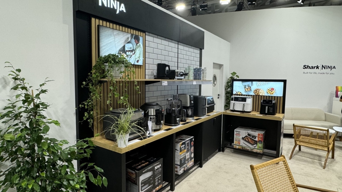 Expositor de la marca Ninja con freidoras de aire, robots de cocina, cafeteras y batidoras sobre una encimera de madera, junto al logotipo de SharkNinja